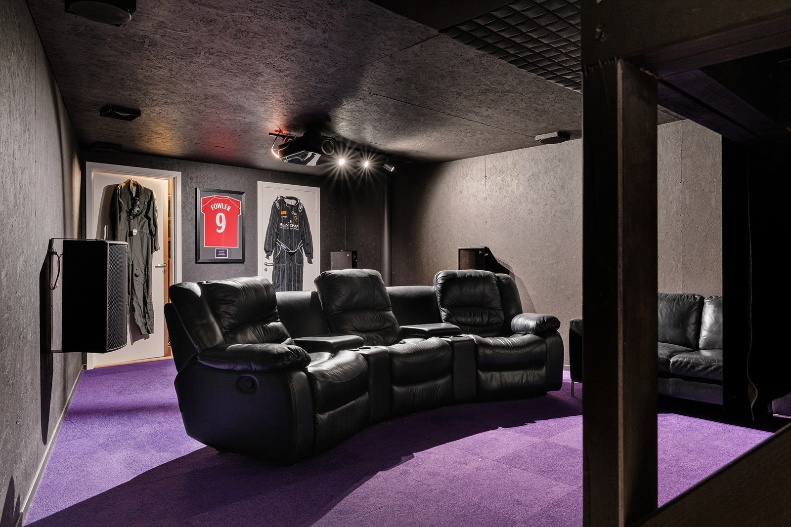 Dedikert hjemmekino med mørklagte overflater, kvalitetsstoler og stort lerret - perfekt for filmkvelder i ekte kinostil. Galleribilde
