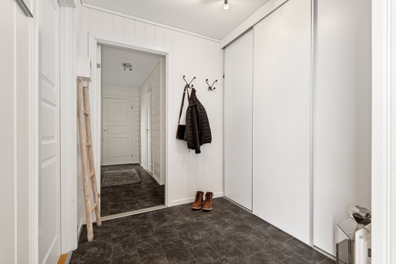 Inngangsparti med en romslig skyvedørsgarderobe. Boligen har også en innvendig og en utvendig bod. Galleribilde