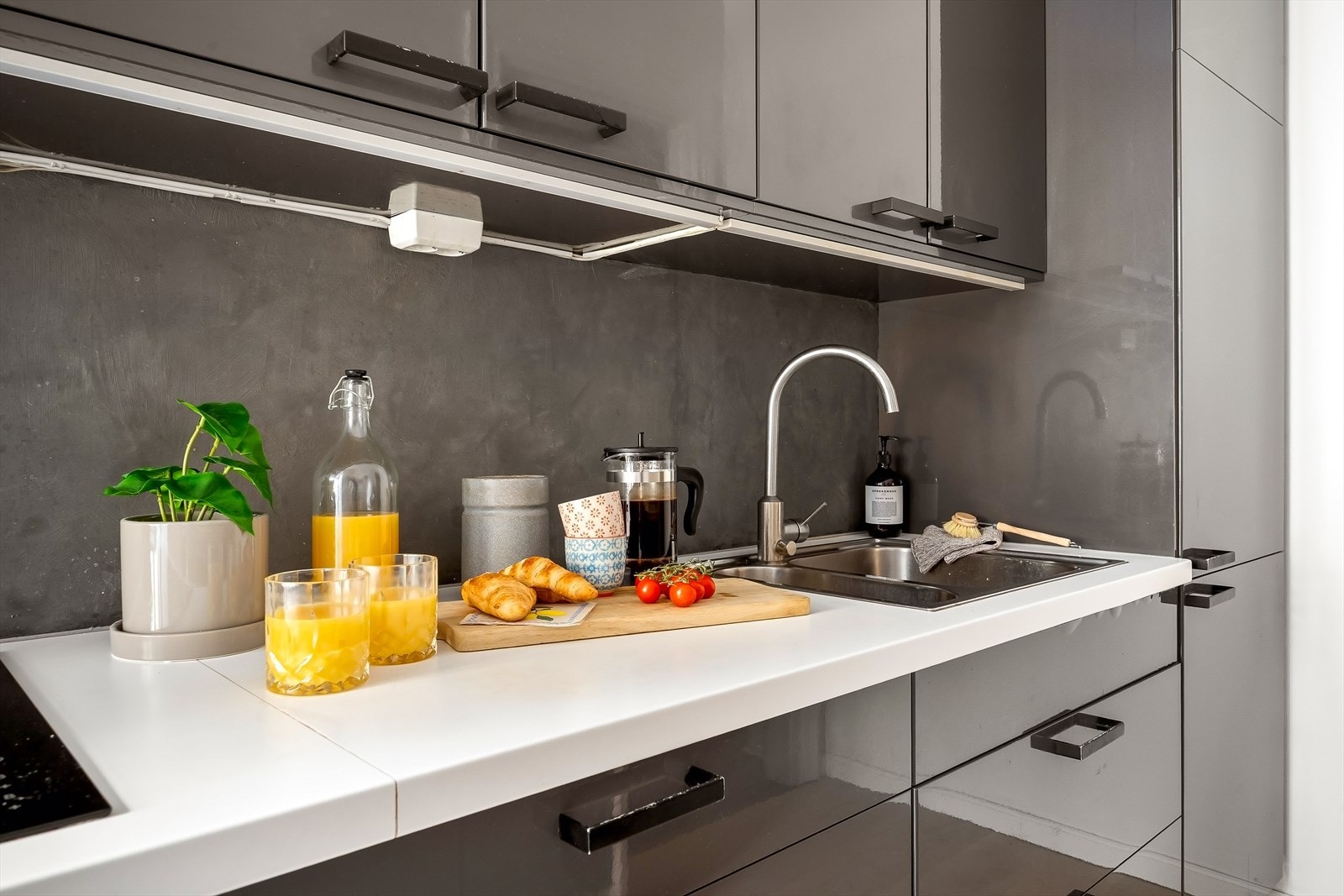 Flott innredning med mørke, glatte fronter og laminert benkeplate. Galleribilde