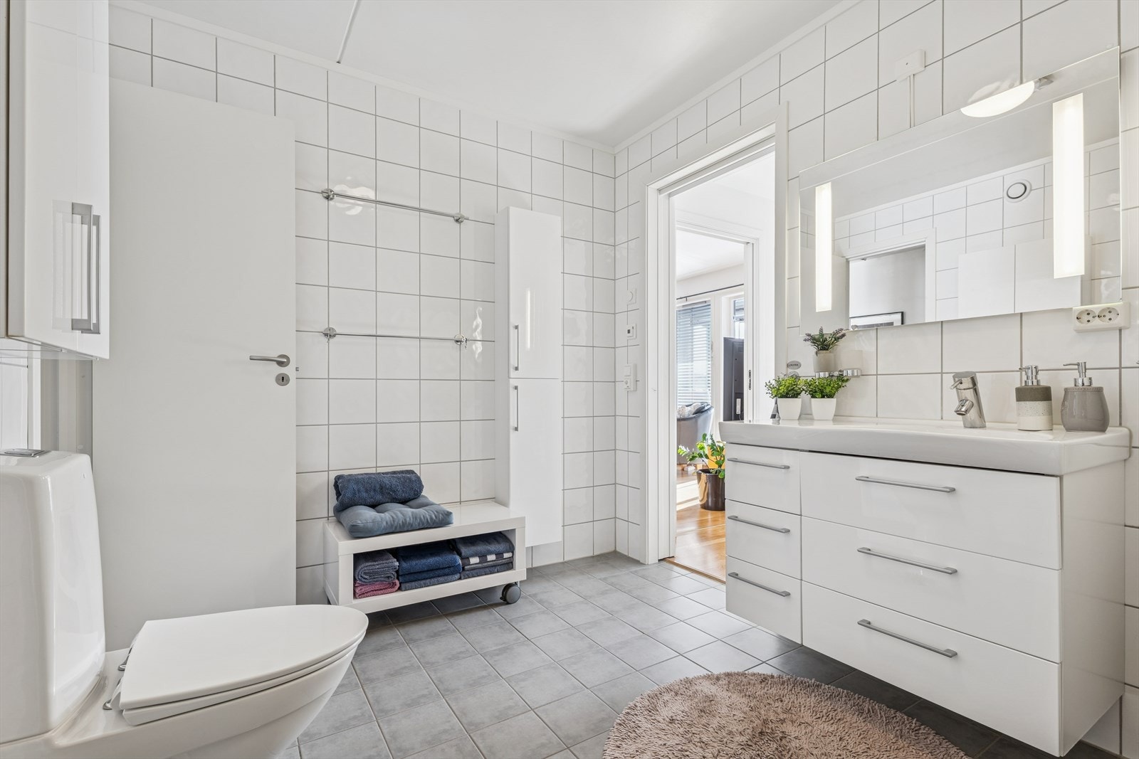 Badet er helfliset og innredet med servant med underskap og gulvmontert WC. Galleribilde