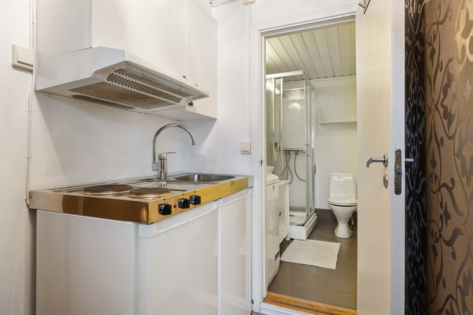 Kjøkkenet består av hybelkjøkken med vaskekum, platetopp, kjøleskap og to overskap. Ventilator med avtrekk ut. Badet innenfor har enkel, men grei innredning. Galleribilde