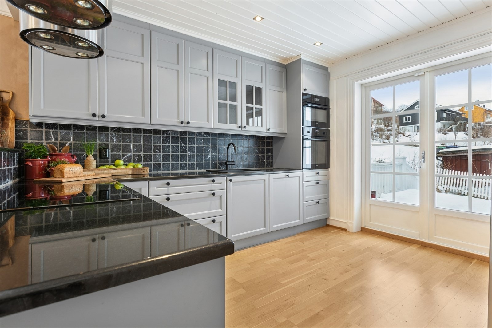 Kjøkkenet er godt utbygget med skap, skuffer og benkeplass. Marmorflisene mellom over- og underskap er både dekorative og praktiske. Galleribilde