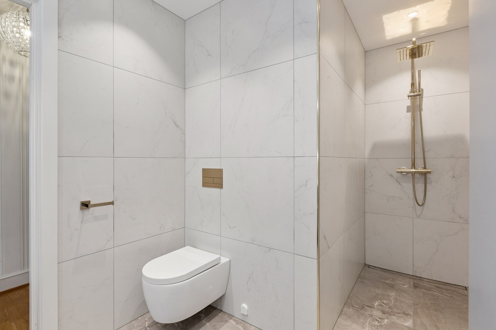 Dusjnisje med slukrenne, moderne dusjgarnityr og integrert hylle. Galleribilde