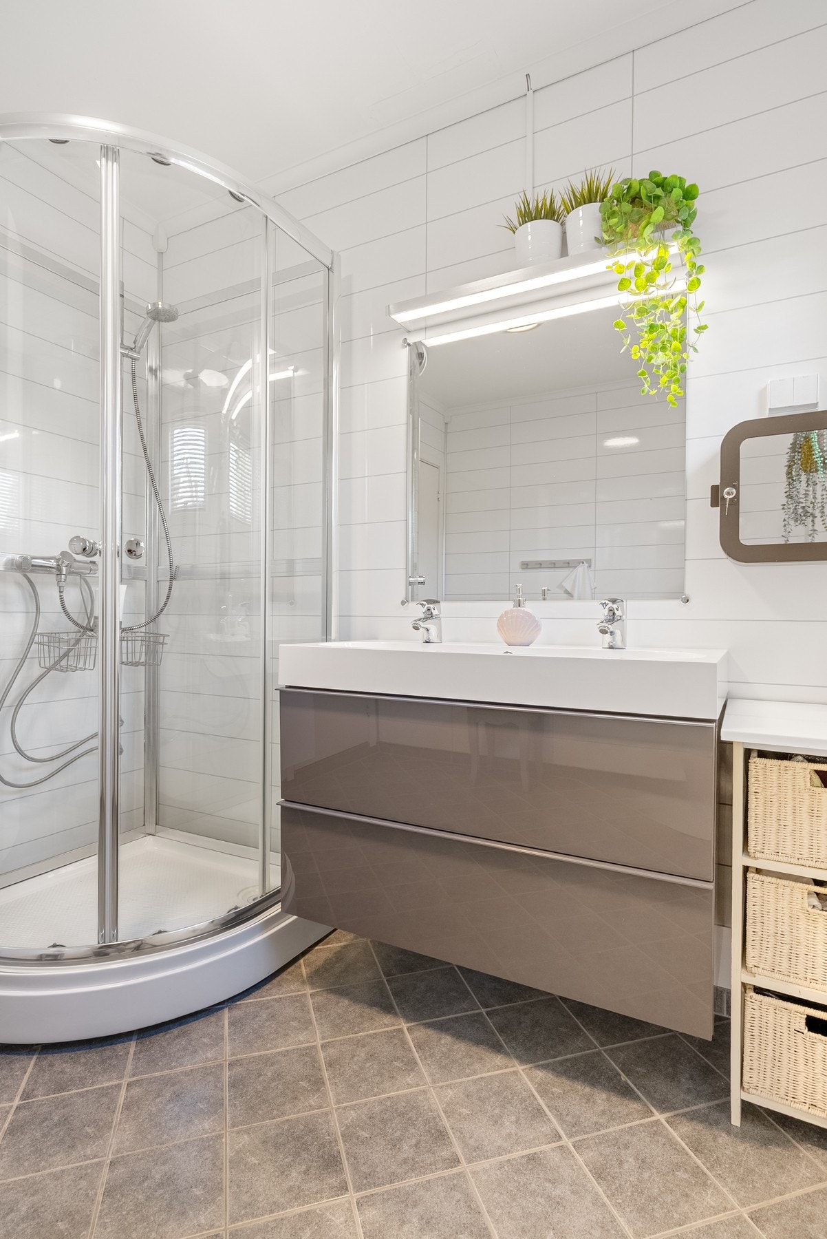 God plass i servantinnredning, godt lys over speil og et romslig dusjkabinett Galleribilde