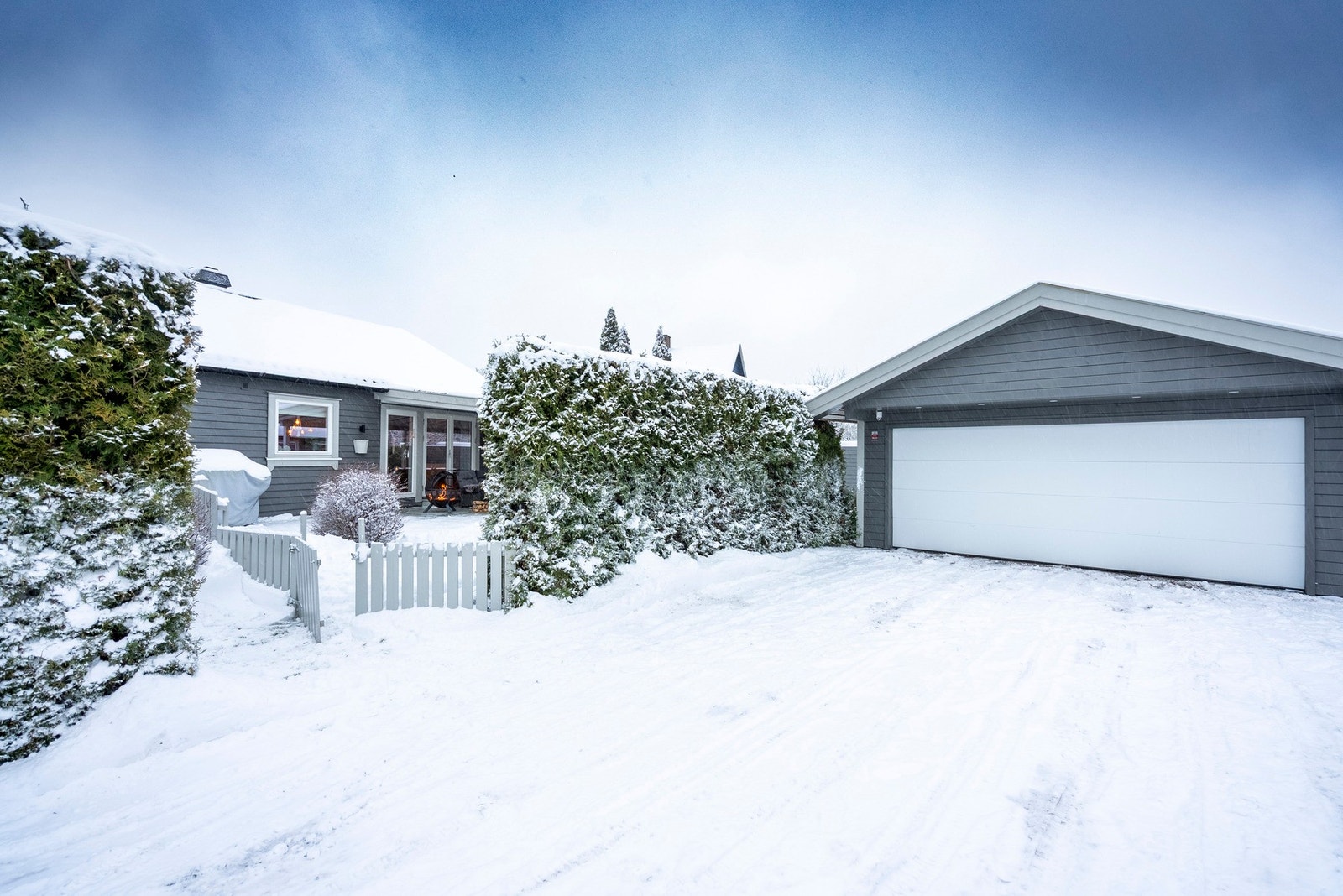 En port i gjerdet gir enkel tilgang til uteområdet og lar deg ønske gjester velkommen direkte fra terrassen eller hagen Galleribilde
