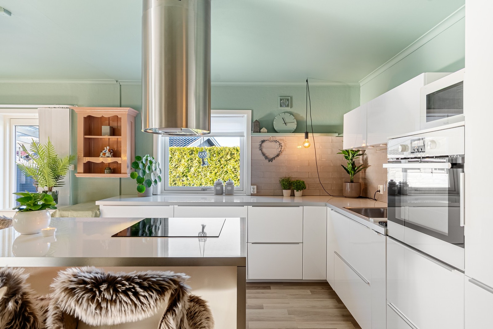 På kjøkkenet har du en tidløs lys innredning med glatte fronter og hvitevarer integrert Galleribilde