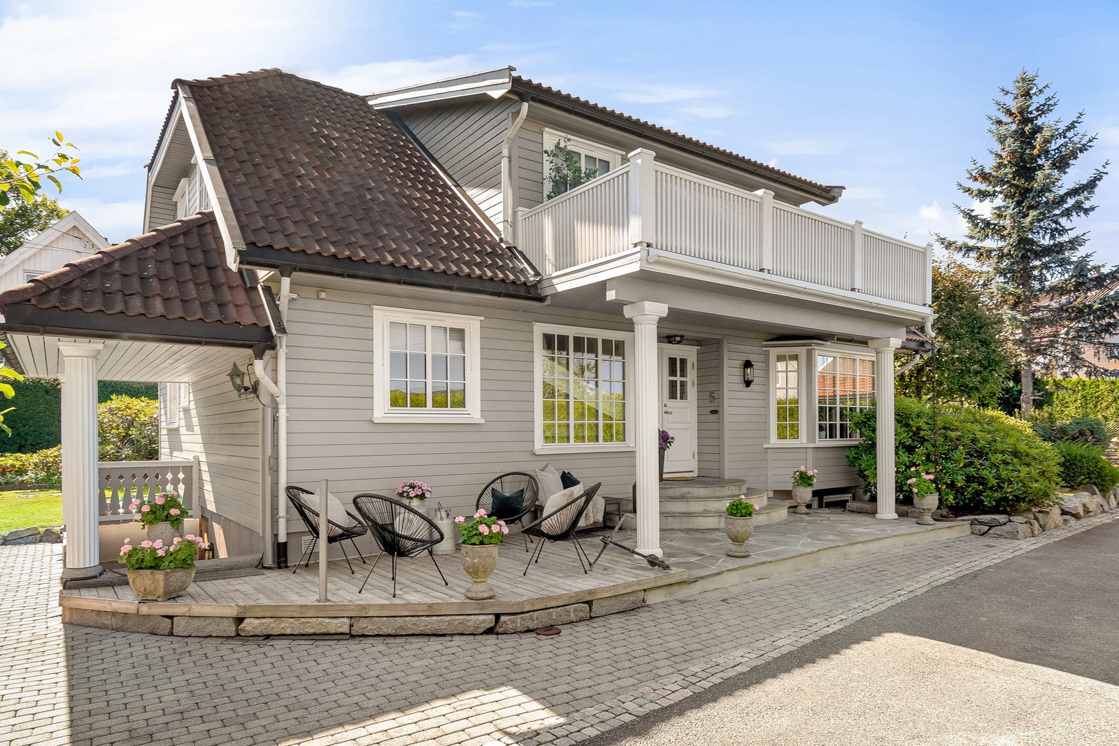 Steinsatt og treterrasse foran huset og stor veranda ut fra 2.etg med nytt moderne rekkverk. Galleribilde