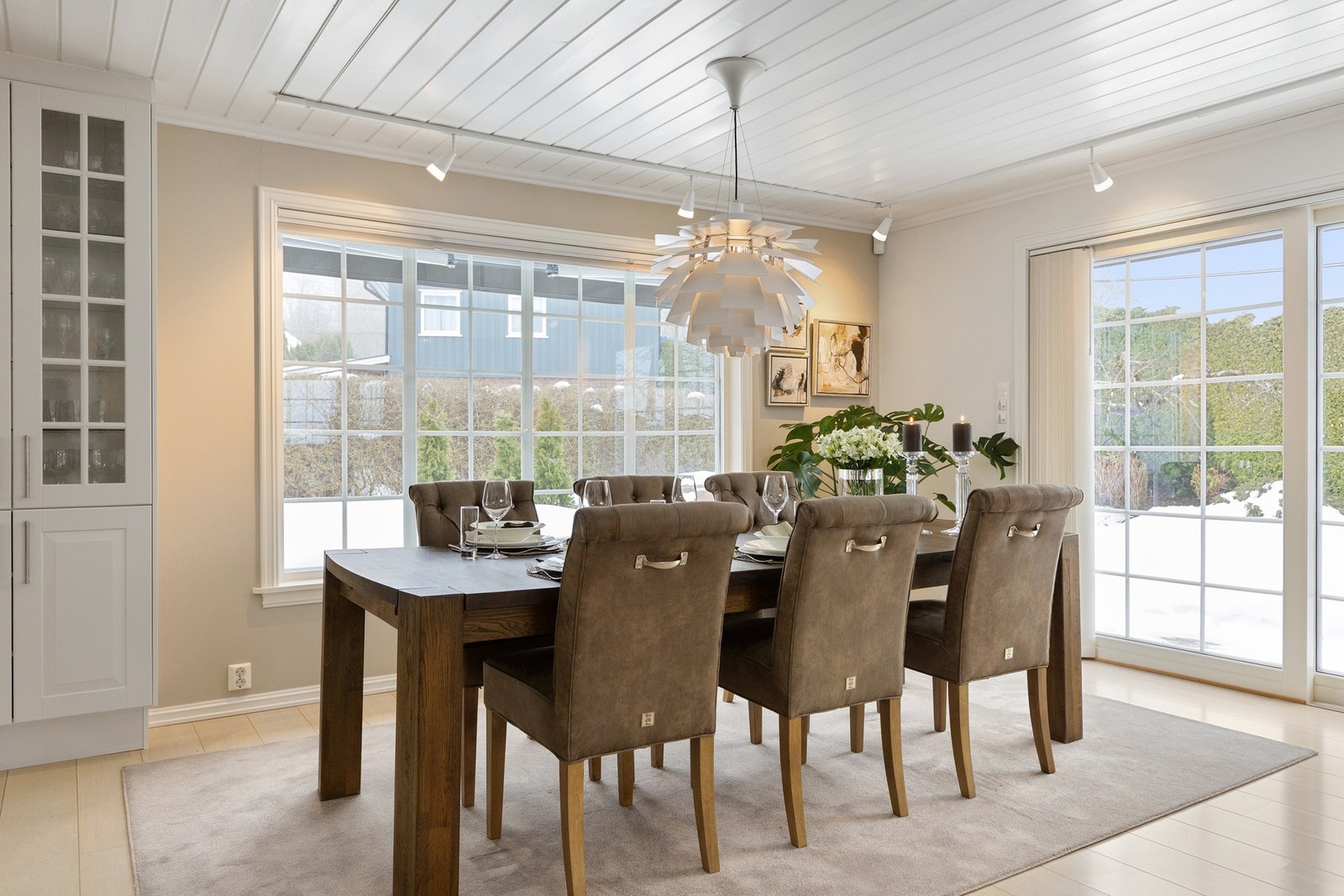 Spisebord utenfor kjøkkenet med store vinduer som gir flott utsyn til hagen Galleribilde