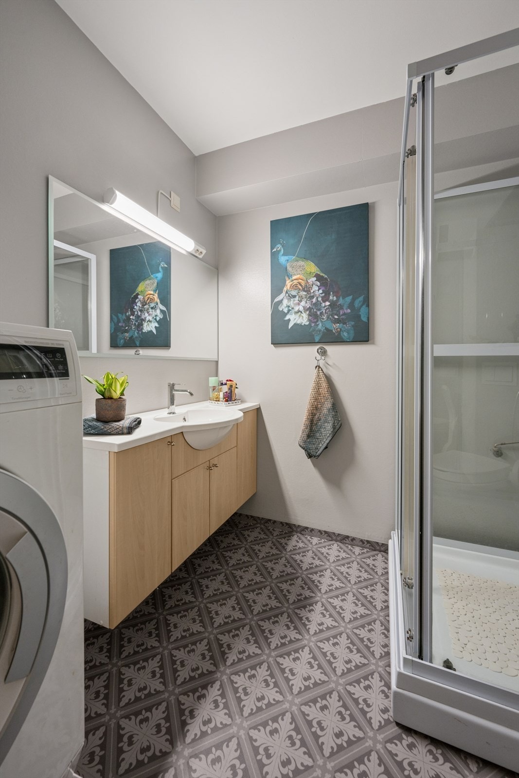 Badet er ellers utstyrt med dusjkabinett, vegghengt toalett og baderomsinnredning med god lagringsplass og nedfelt servant. I tillegg har man opplegg for vaskemaskin. Galleribilde