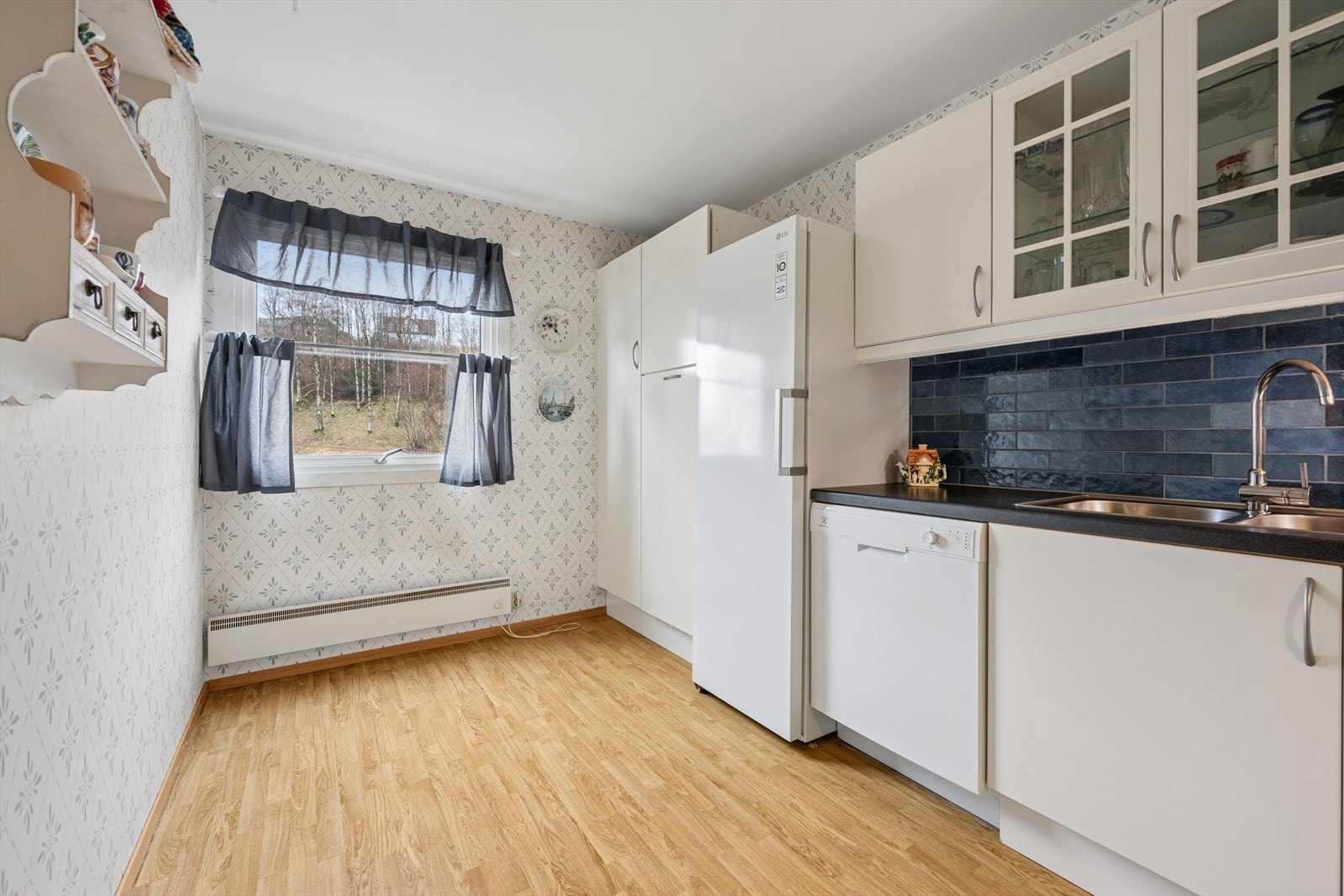 Kjøkkenet er ellers utstyrt med frittstående komfyr, kjøleskap, oppvaskmaskin og kjøkkenventilator som er tilkoblet til fellesanlegget. Galleribilde