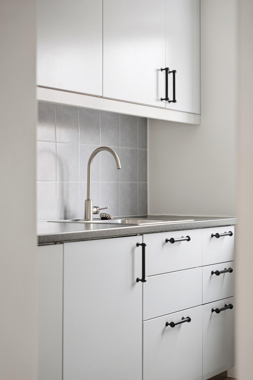 Kjøkkenet er innredet med glatte, folierte fronter og laminat benkeplate med nedfelt rustfri kum. Galleribilde