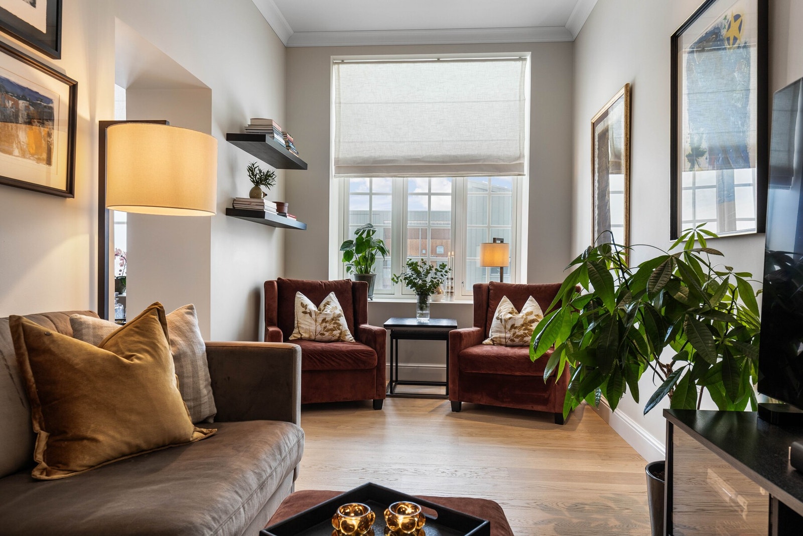 Dette rommet fungerer som en perfekt tilbaketrukket sone i boligen, hvor man kan trekke seg tilbake for å se en god film, slappe av i en romslig sofa eller nyte en bok i en behagelig lenestol. Galleribilde