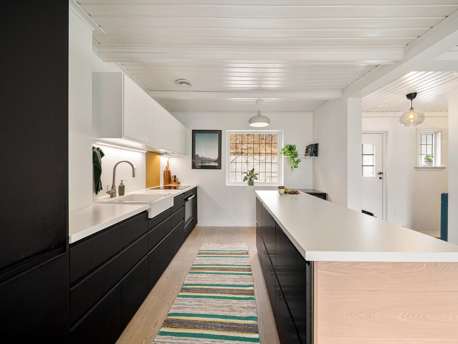 Moderne kjøkkeninnredning med slette fronter og benkeplate av laminat. Galleribilde