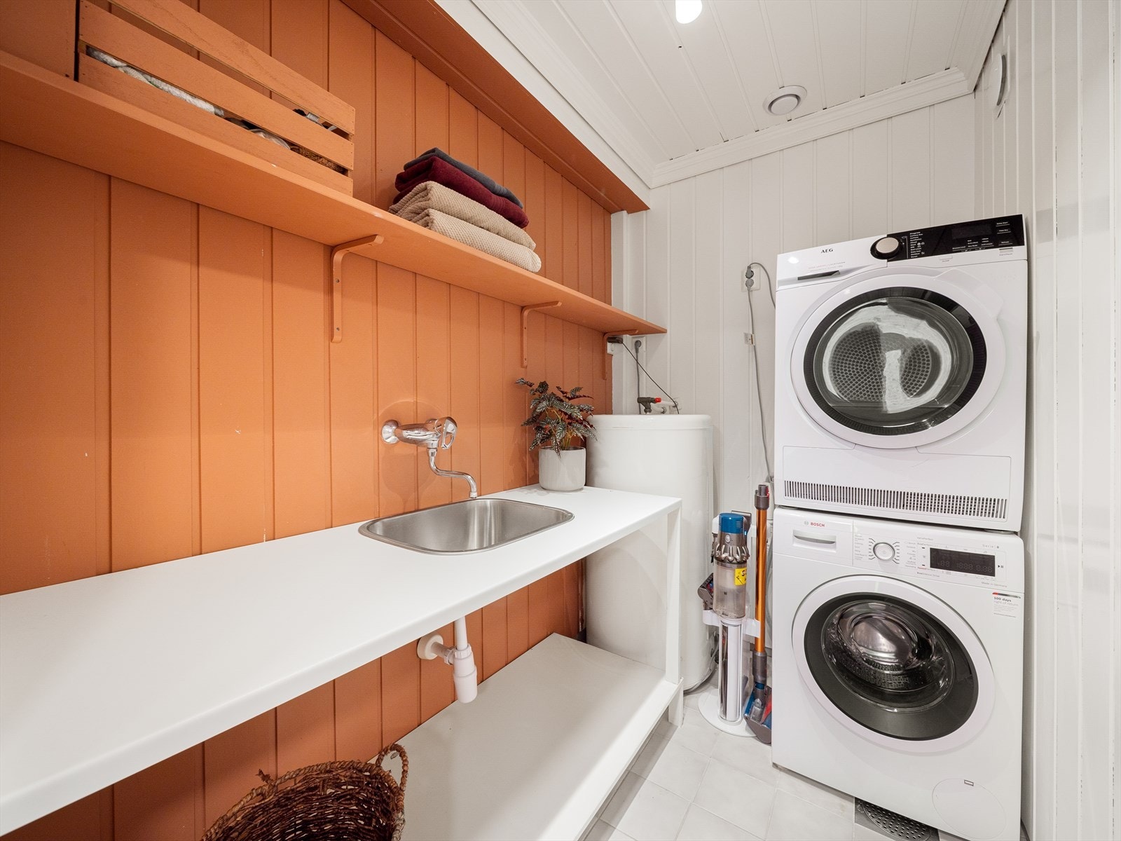 Vaskerommet har fliser på gulv med varmekabler. Innredet med benkeplate og utslagsvask, og opplegg til vaskemaskin og tørketrommel. Galleribilde