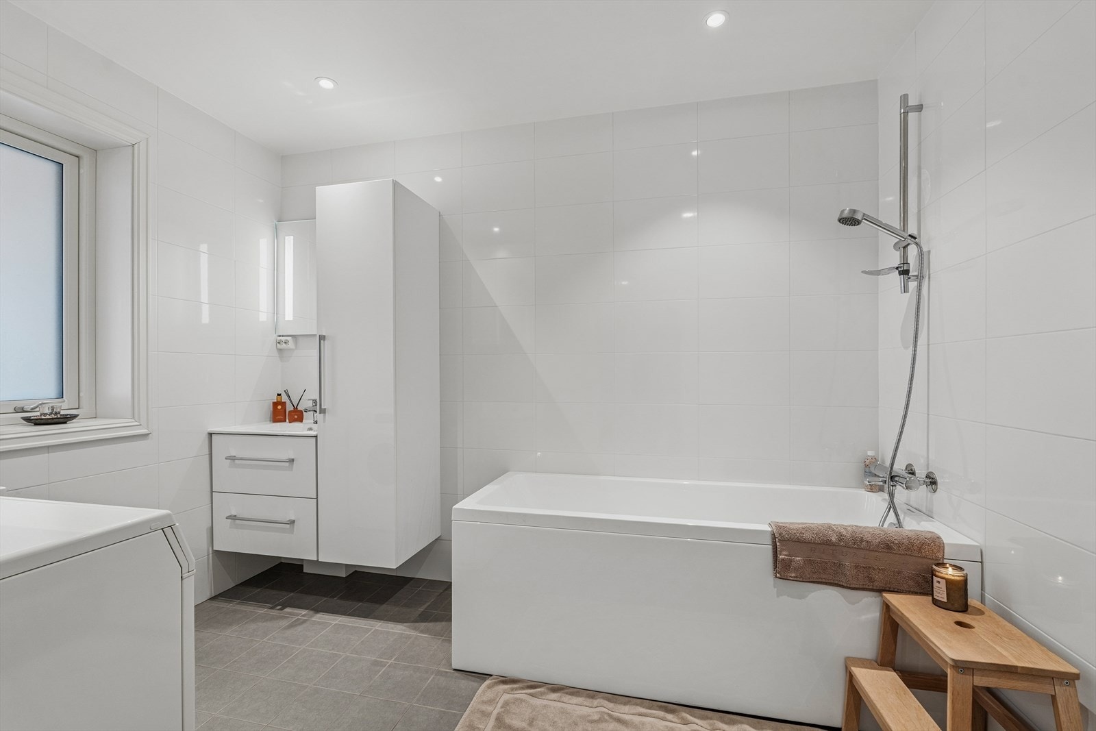 Lekkert flislagt bad med badekar og dusj. Galleribilde