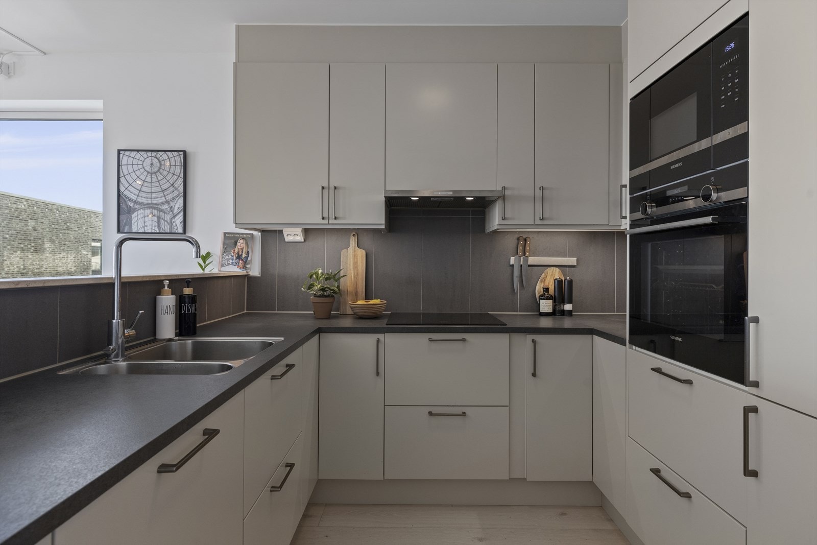 Her er det rikelig med skapplass, fliser over kjøkkenbenken og belysning under overskap. Hvitevarer fra Siemens inkluderer induksjonstopp, mikro, stekeovn, kjøl/frys og oppvaskmaskin, samt ventilator fra Røroshetta over kokesonen. Galleribilde