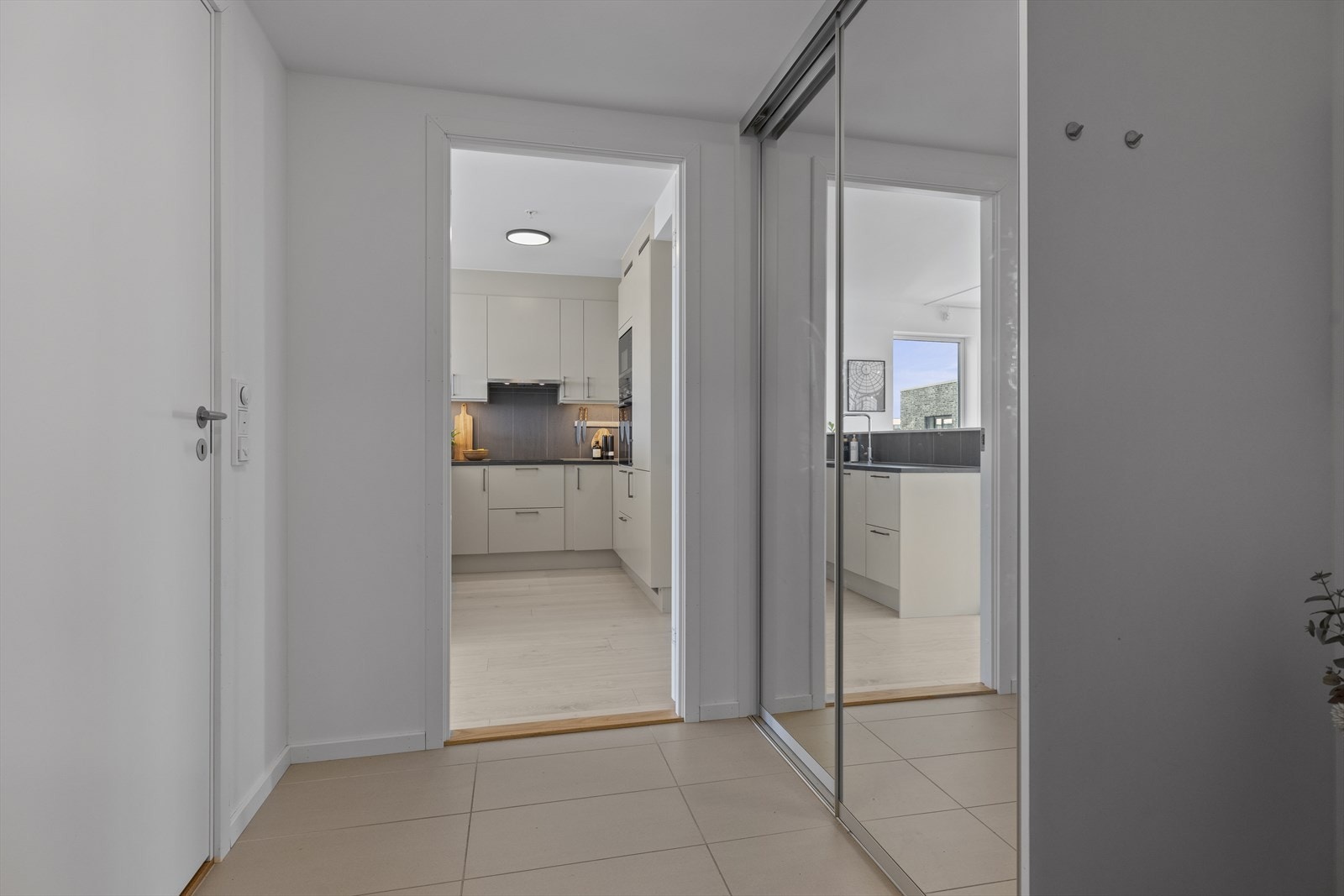 Flislagt entré med stor skyvedørsgarderobe ønsker deg velkommen inn i leiligheten. Galleribilde