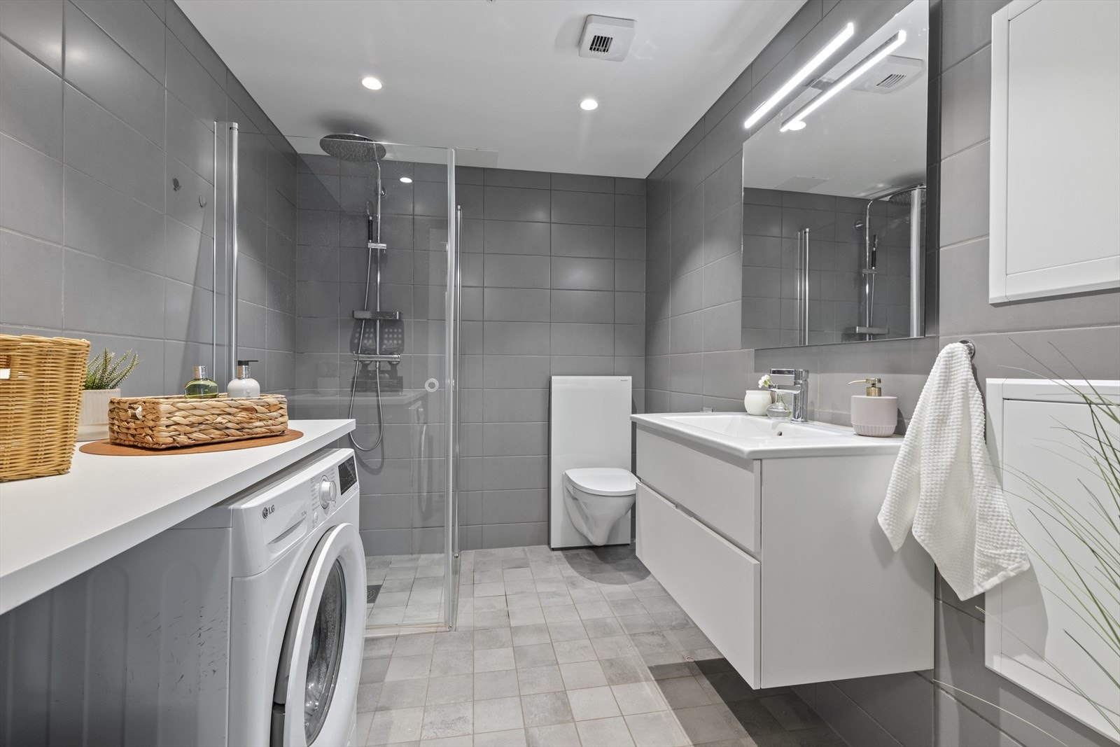 Regndusj og stilrent servantskap med god belysning over speilet. Galleribilde