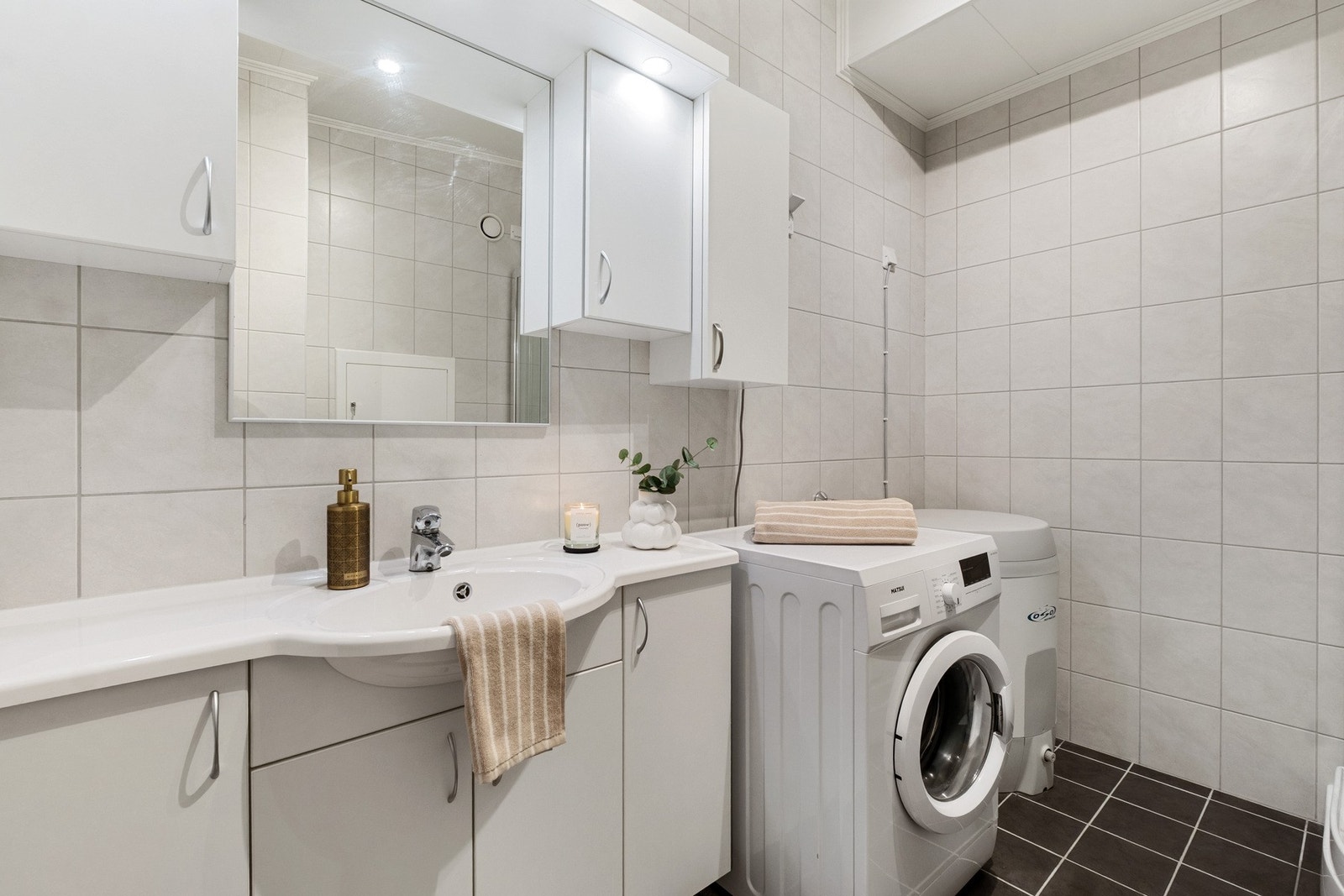 Opplegg for vaskemaskin, og godt med oppbevaringsplass i over- og underskap. Galleribilde