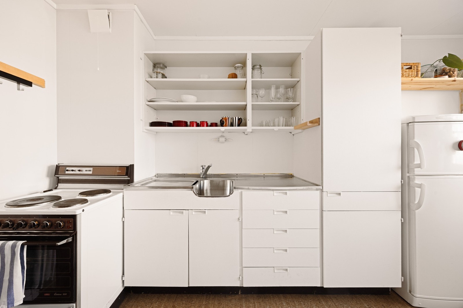 Kjøkken med klassisk innredning og åpne hyller som gir et lett og uformelt preg. Galleribilde