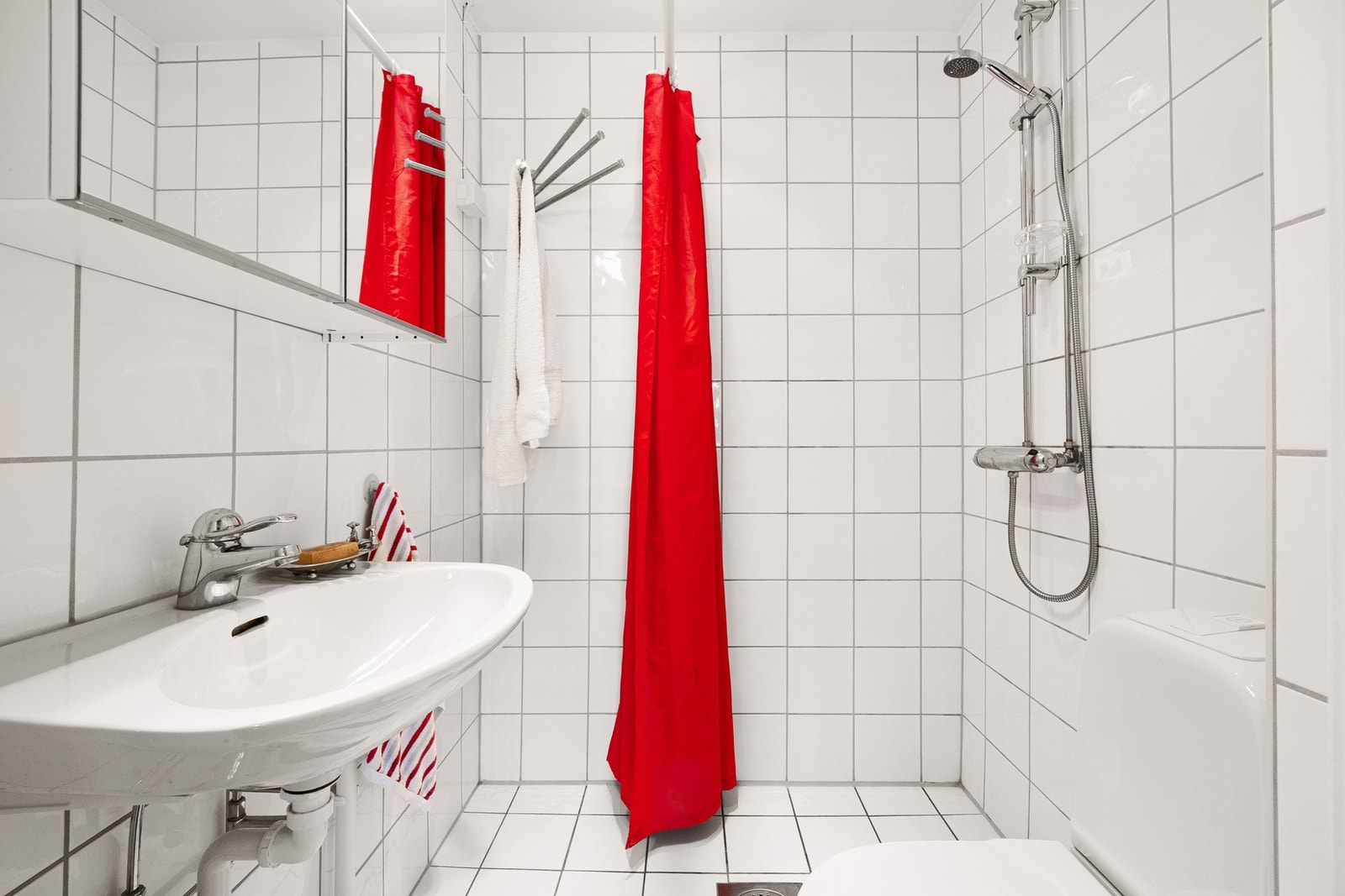 Flislagt baderom fra 2005/2006 med gulvvarme pusset opp i regi borettslaget. Her med dusjnisje, toalett og servant. Galleribilde