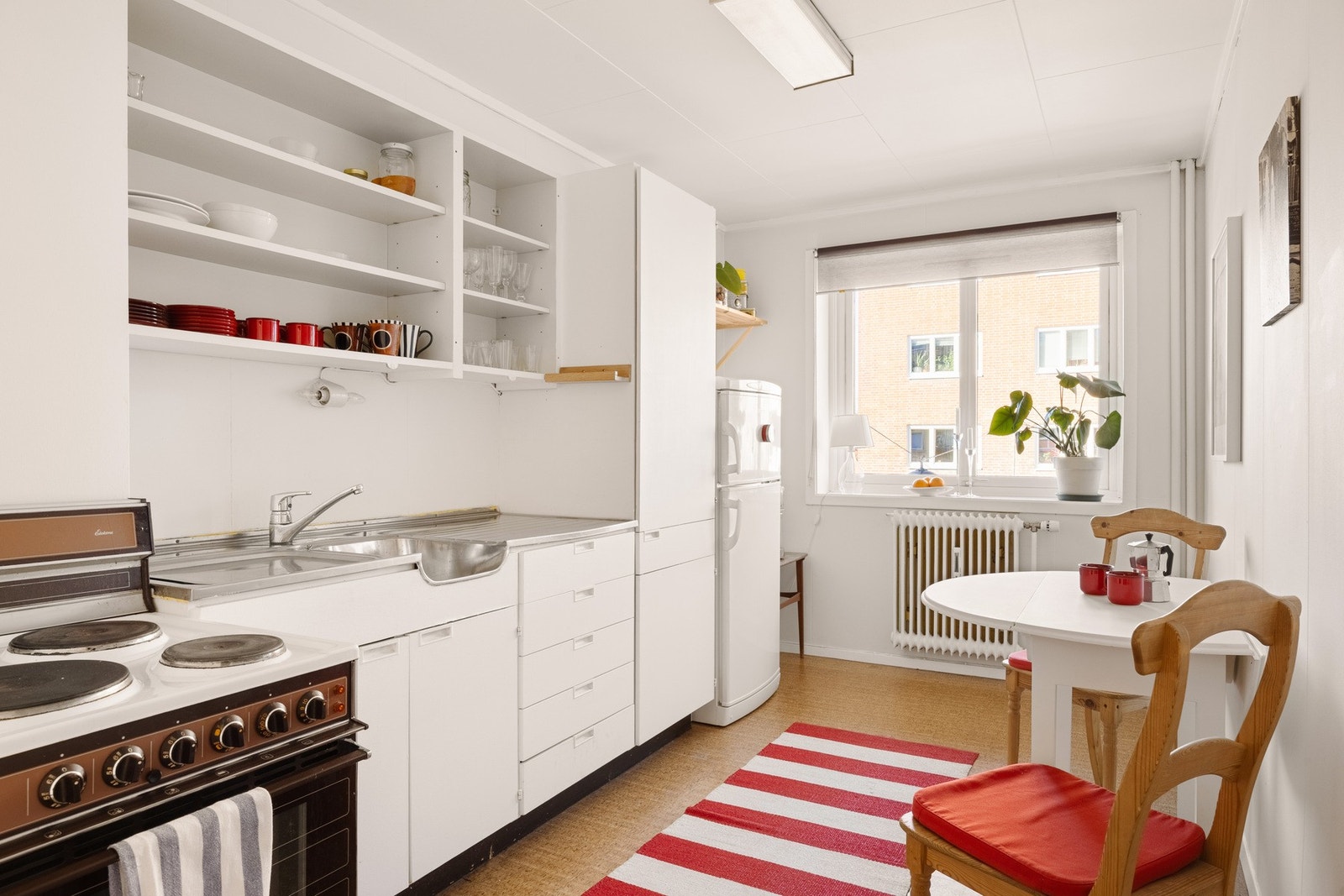 Et retro kjøkken med naturlig lys og plass til en koselig spisegruppe. Galleribilde