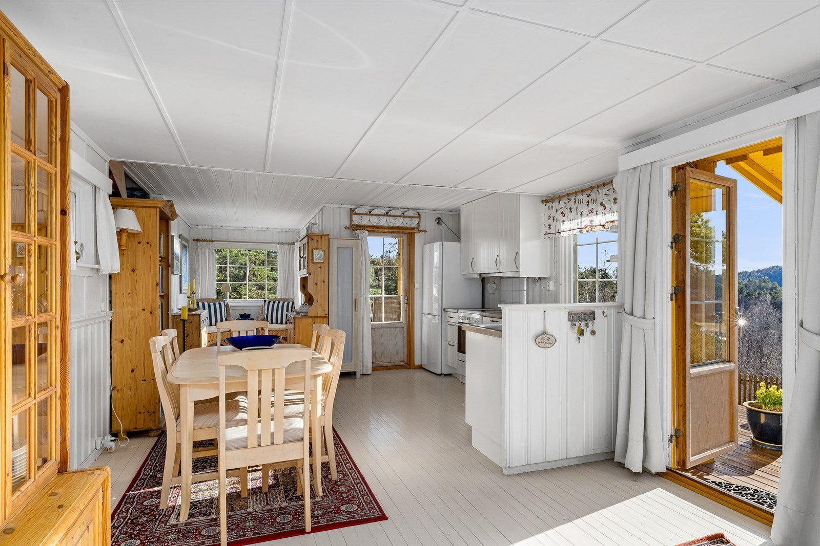 Oppholdsrommet med flere vinduer og utgangsdører med glassfelt gjør stuen og kjøkkenet til et lyst og godt sted å oppholde seg. Galleribilde