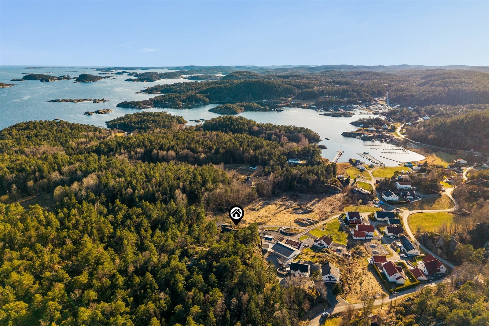 Hytta ligger på en voll med skog i bakkant med gamle, høyreiste furutrær. Stiene går på kryss og tvers gjennom skogbunn og fører til en kyststi. Galleribilde
