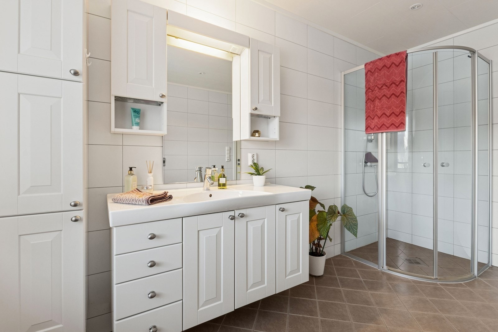 Baderommet har fliser på vegger og gulv, samt elektriske varmekabler i gulvet. Galleribilde