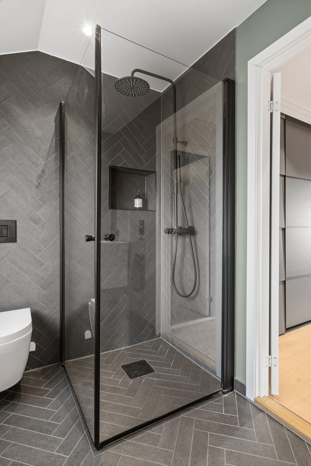 Dusjnisje med innfellbare dører og regnskogdusj, integrert hylle i dusjvegg. Galleribilde