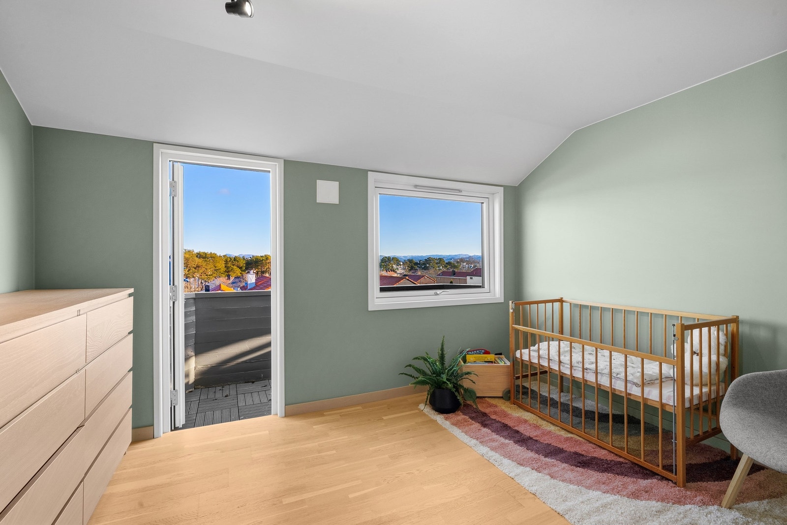 Soverom I med god plass til stor seng, nattbord og kommode om ønskelig. Her er det parkett på gulv, vegger malt i en fin farge og utgang til østvendt balkong. Flott utsikt fra rommet og balkong. Galleribilde