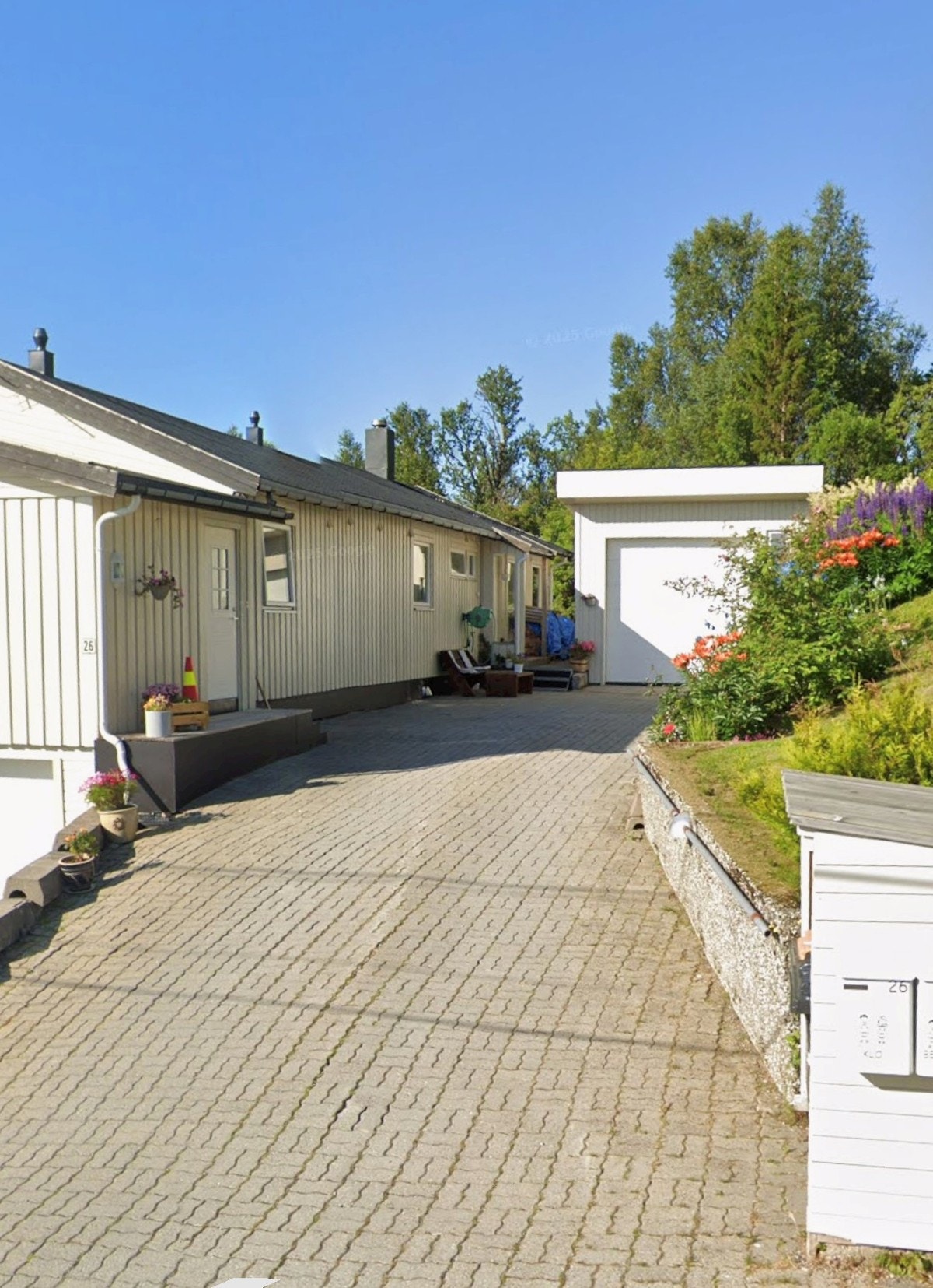 Takoverbygd inngangsparti og steinbelagt innkjørsel og parkering. Selgers private foto. Galleribilde