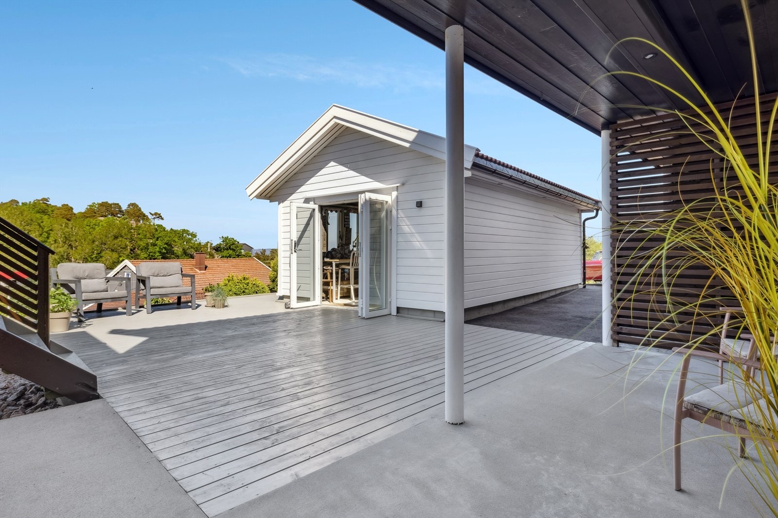 Inngangspartiet er overbygget med terrasse og asfalterte områder Galleribilde