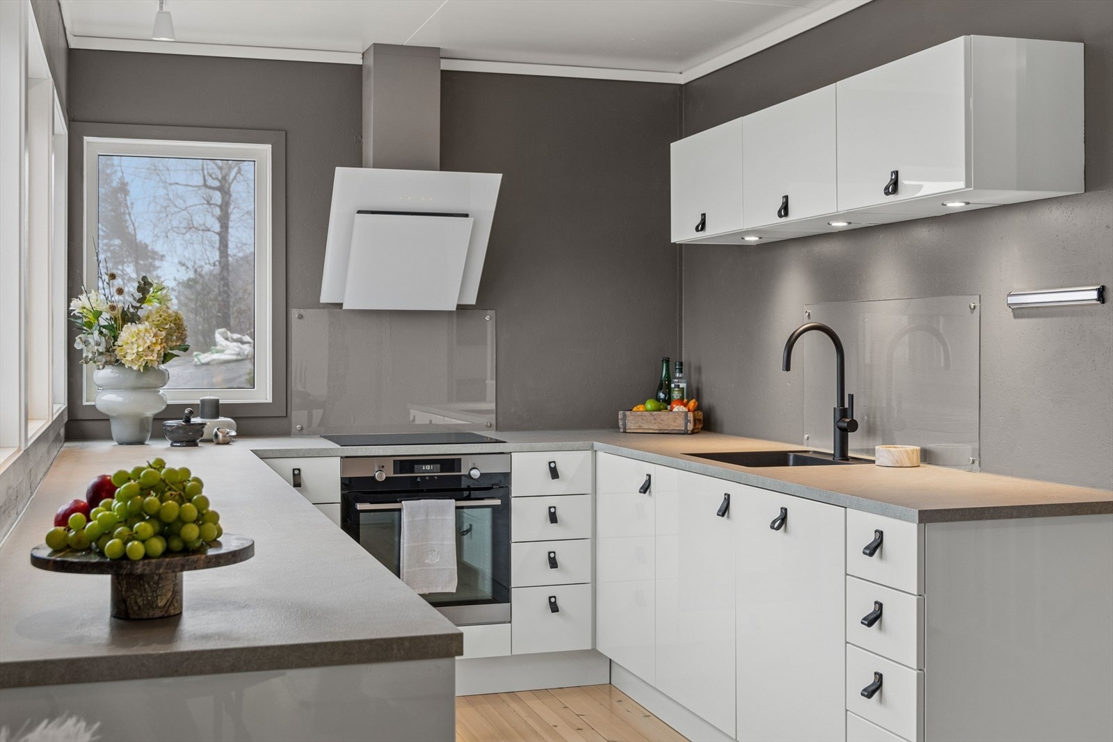 Kjøkkenet har integrerte hvitevarer og underlimt vask for et moderne uttrykk. Galleribilde