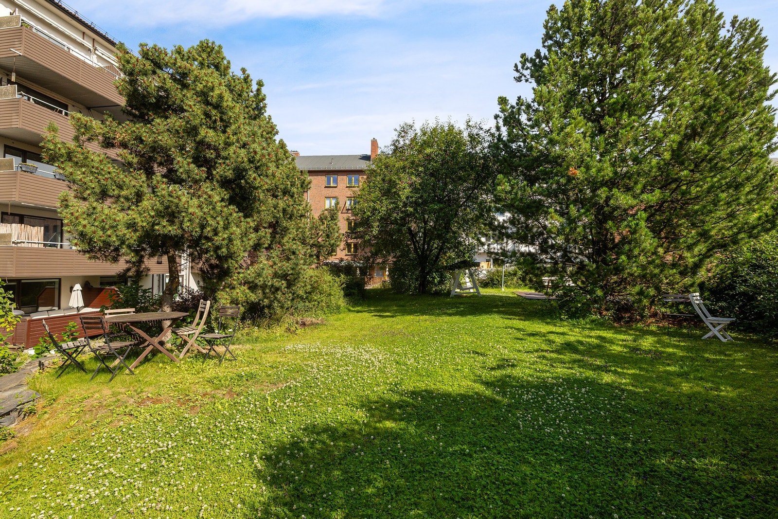 Bakgården er pent opparbeidet med frodig beplantning og sittebenker som inviterer til hyggelig samvær mellom beboerne. Galleribilde