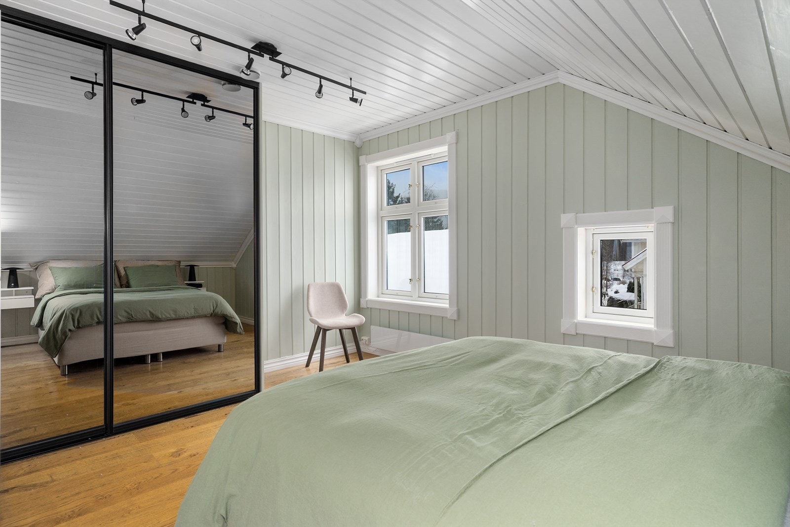 Praktisk skyvedørsgarderobe for klesoppbevaring og oppvarming via panelovn. Skyvedører med speilfronter og mørk innramming. Galleribilde