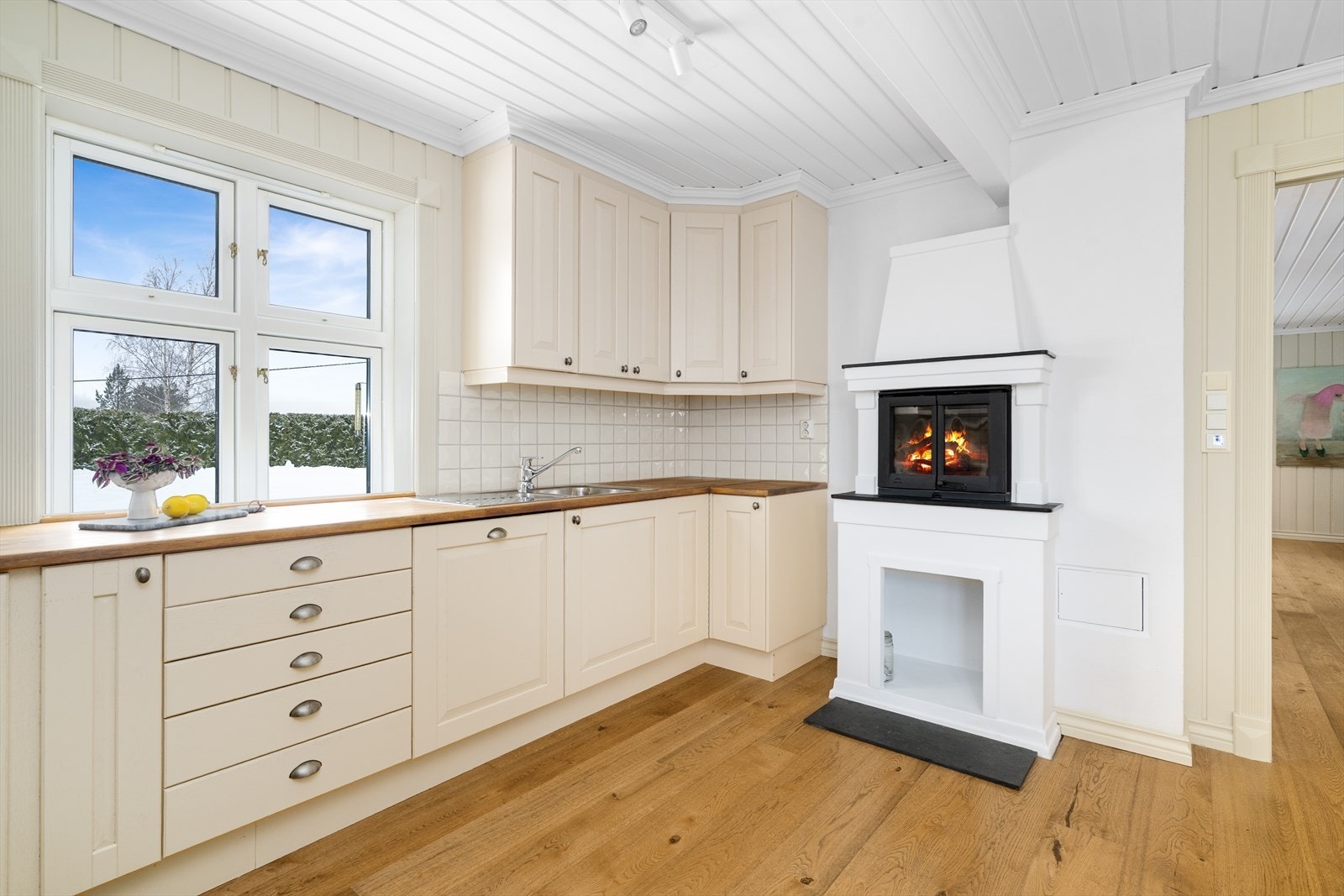 Flis på vegg over heltre benkeplate med gode arbeidsflater, nedfelt platetopp og nedfelt benkebeslag i rustfritt stål. Ventilator med avtrekk ut. Galleribilde