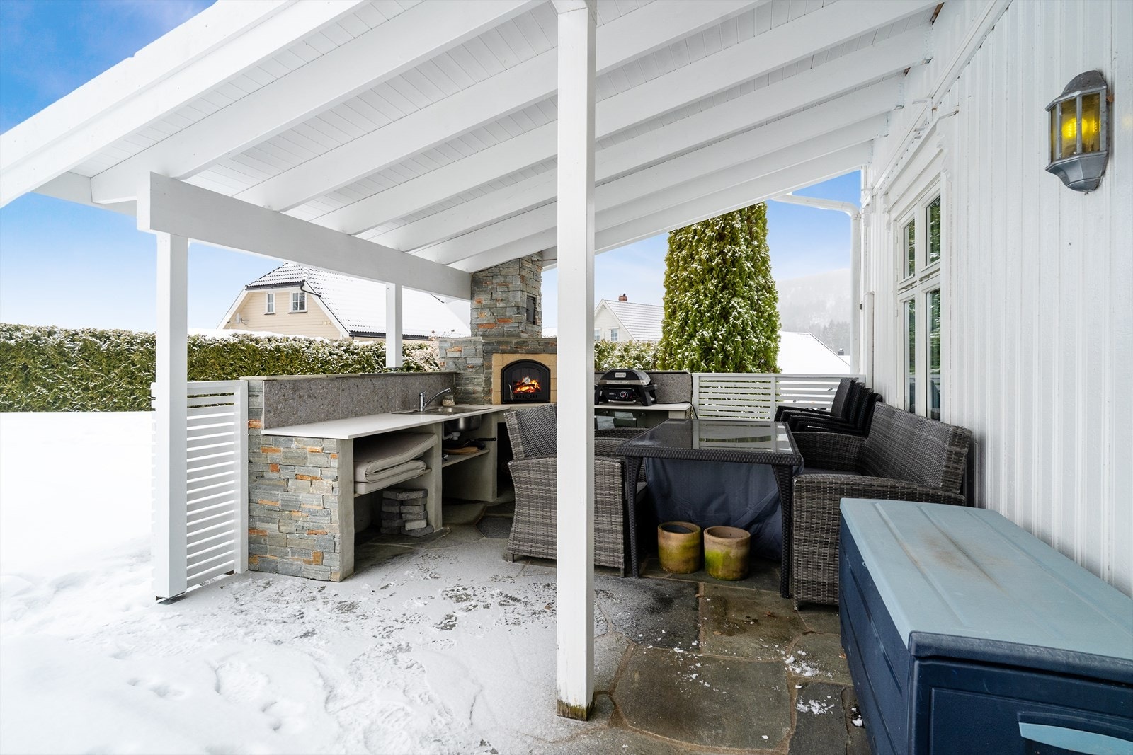 Stor skiferlagt terrasse mot vest. Terrassen ligger usjenert til og er overbygget ut fra stuen, i form av overliggende balkong ut fra soverom i 2. etasje. Galleribilde