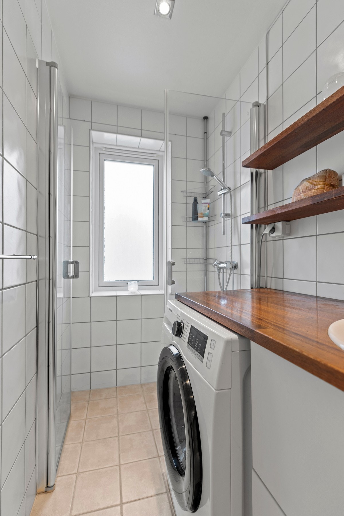 Det er utstyrt med servant, gulvstående toalett, dusj på gulv og opplegg for vaskemaskin Galleribilde