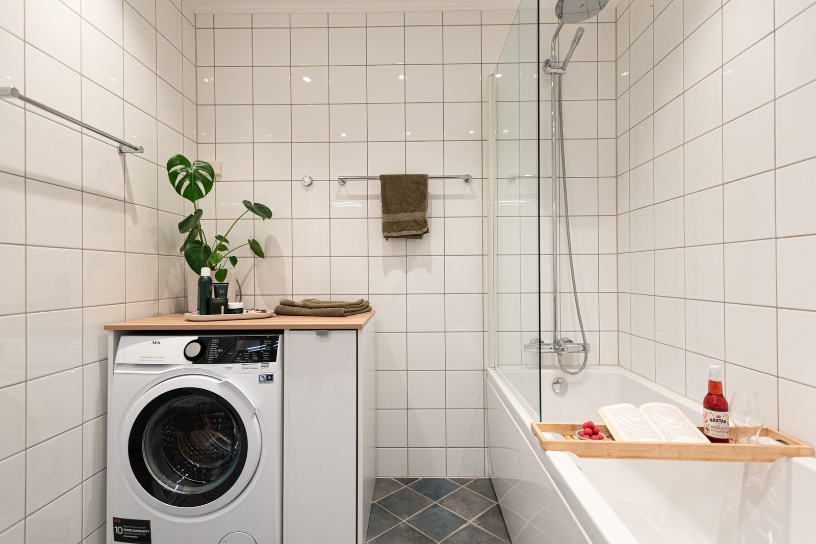 Baderommet er innredet med servantskap, heldekkende servant. speilskap med belysning over servant, vegghengt toalett og badekar med halvvegg i glass og dusjutstyr. Galleribilde