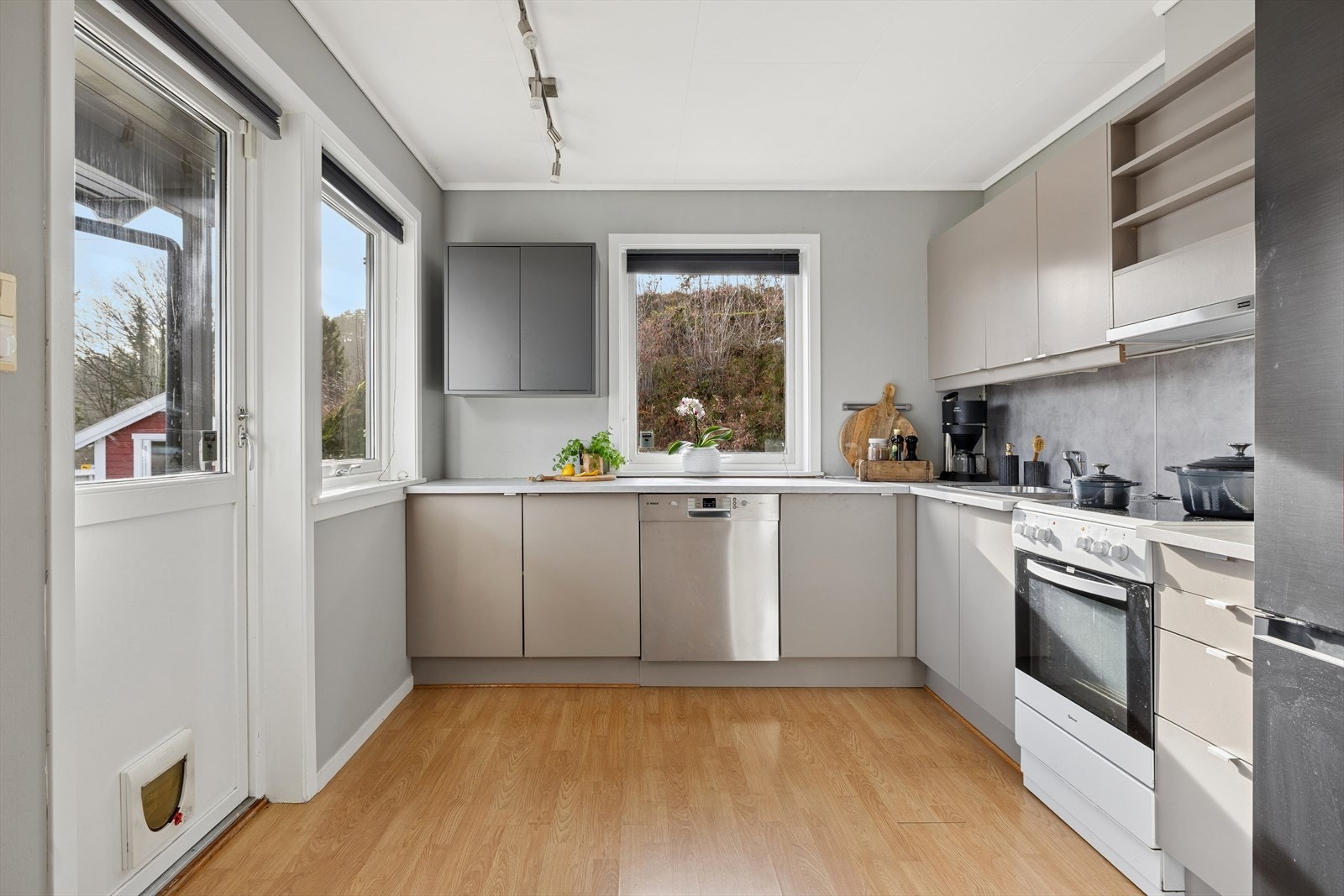 Pent kjøkken med moderne farger på fronter og rikelig med benk- og skapplass. Oppvaskmaskin, komfyr og kjøleskap medfølger Galleribilde