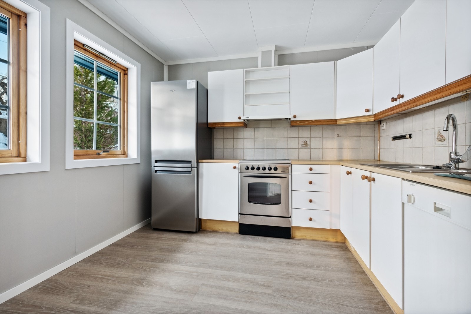 På kjøkkenet finner vi ovn, kjøleskap, oppvaskmaskin og godt med oppbevaring Galleribilde