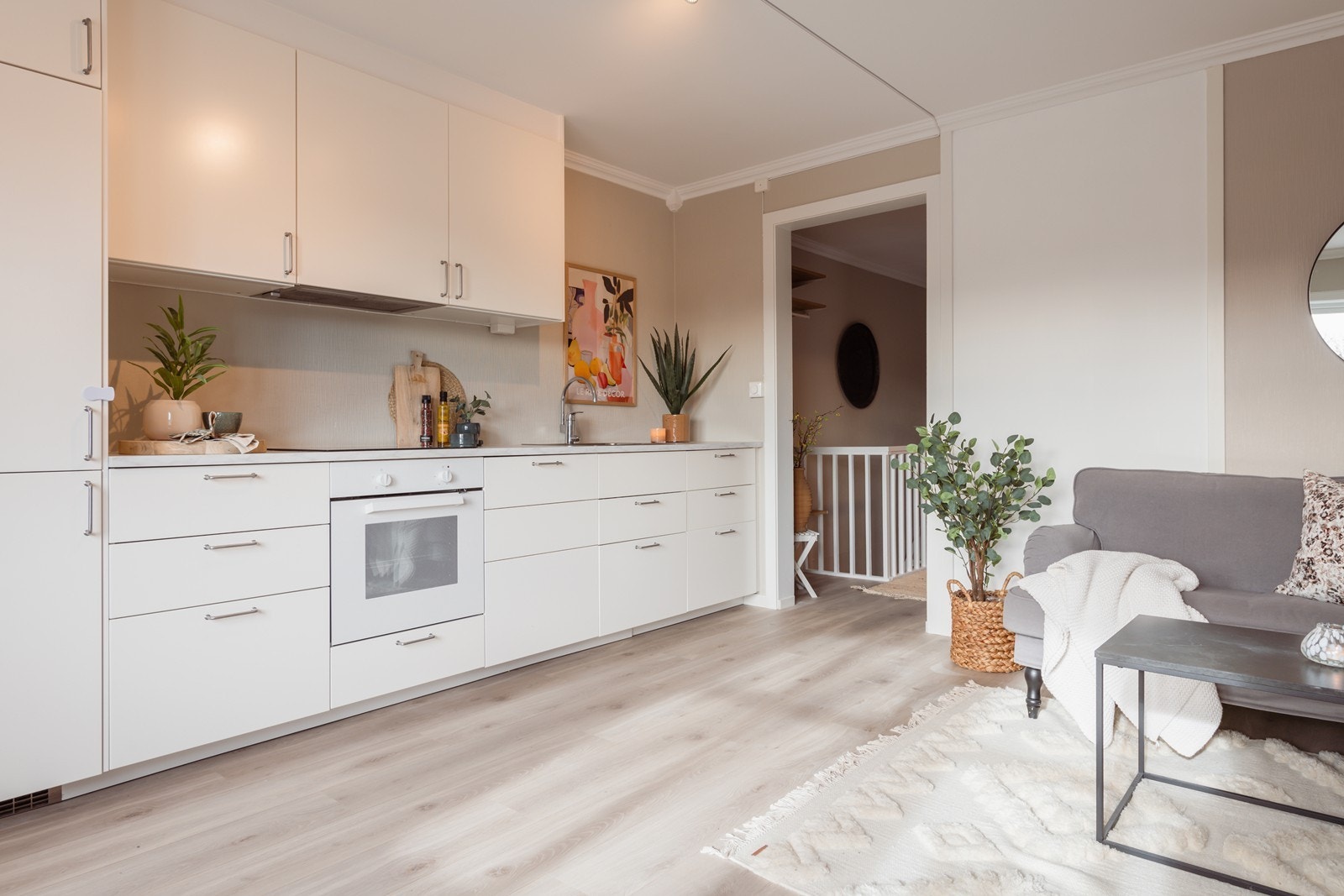 Kjøkken i åpen løsning med stue. Kjøkkeninnredning med slette fronter, laminat benkeplate, stål oppvaskkum. mekanisk ventilator og integrerte hvitevarer. Galleribilde