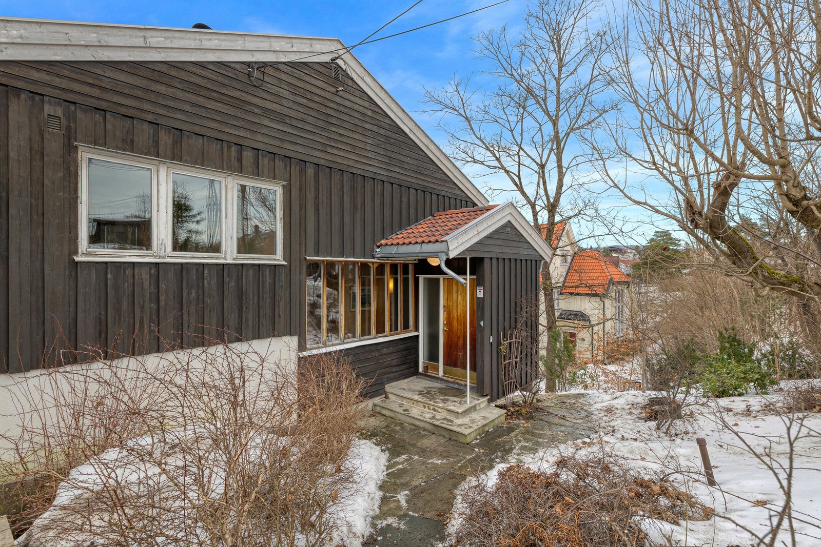 Eneboligen har hyggelig adkomst via et overbygget inngangsparti med trapp i betong, kledd med naturstein. Galleribilde
