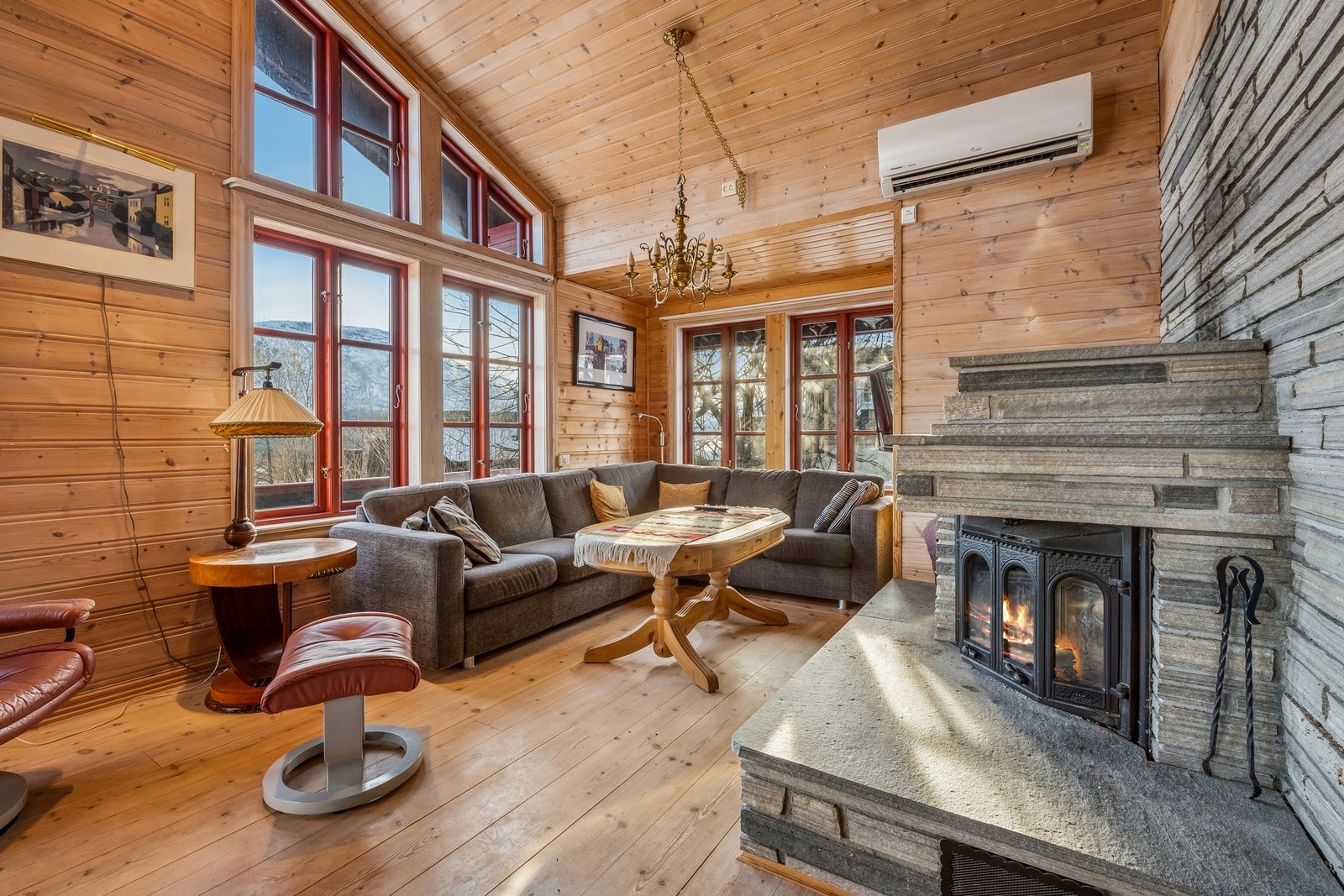 Stue med god takhøyde. Peis innsats kledd med skifer. Varmepumpe. Galleribilde