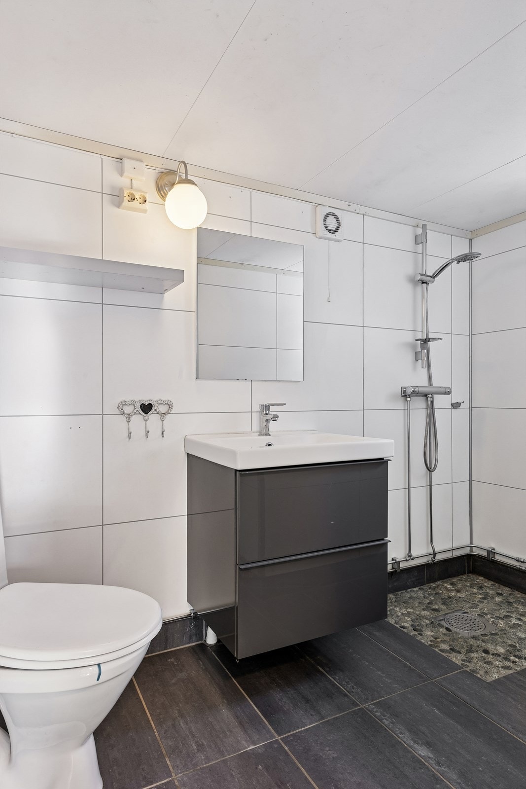 Badet har keramiske fliser og rullestein på gulv, med varmekabler for komfort. Galleribilde