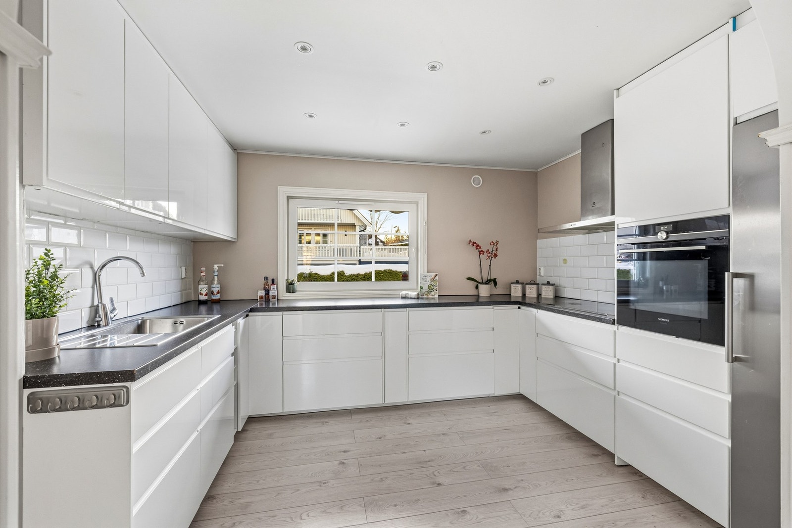 Kjøkkeninnredningen består av høyglans fronter og delvis integrerte hvitevarer, overskap og fritthengende ventilator med kullfilter, laminert benkeplate med oppvaskkum med ett-greps armatur samt bred induksjons koketopp. Galleribilde