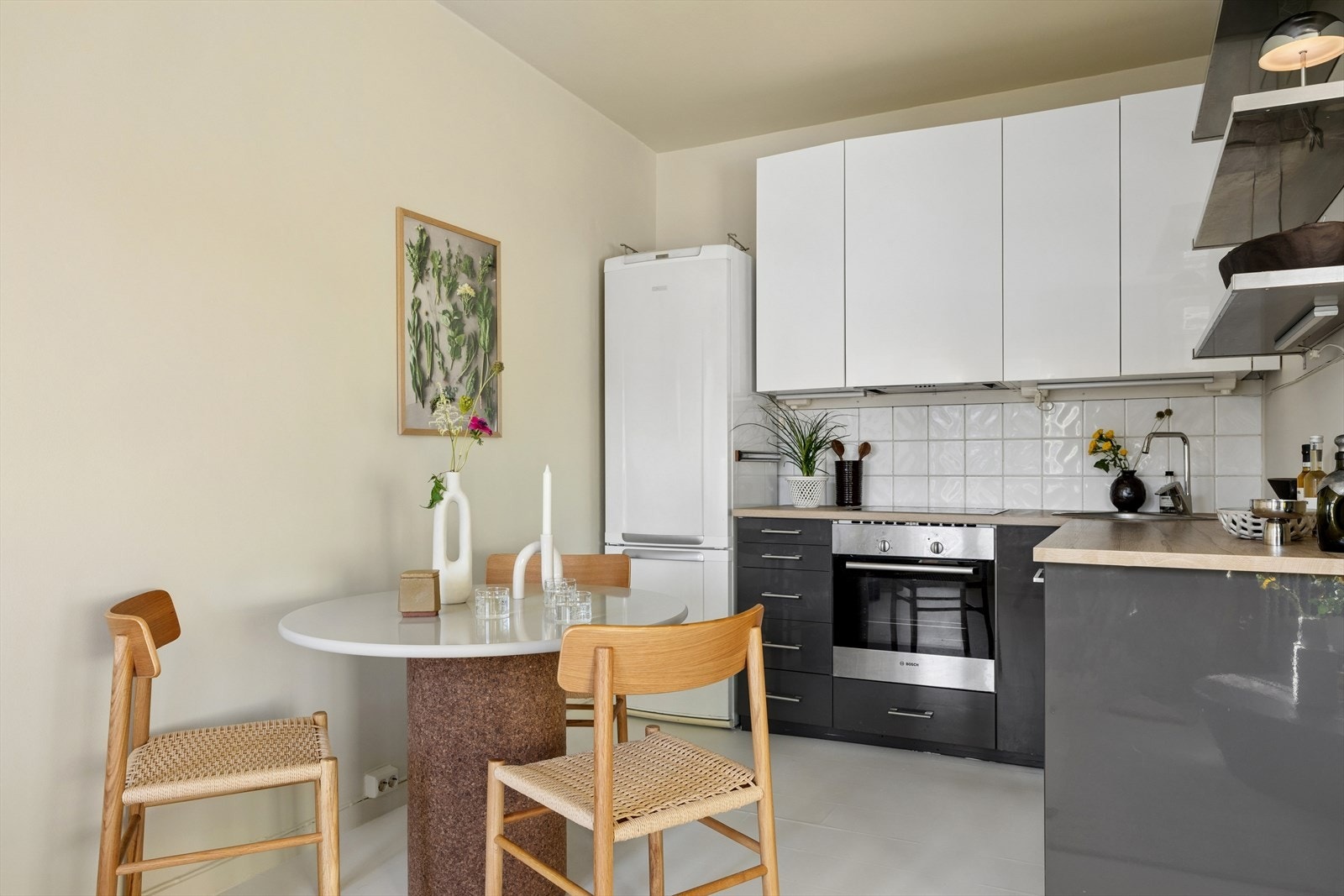 Kjøkkeninnredningen fra 2014 har hvite og grå fronter og en benkeplate i heltre. Galleribilde