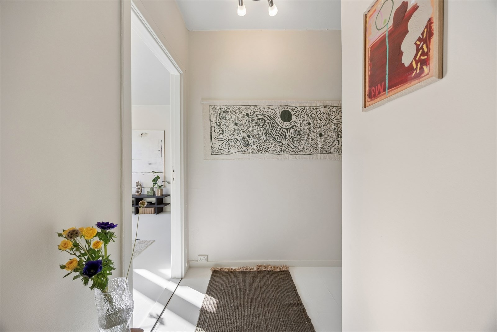 Velkommen inn i en lys entré som leder videre til leilighetens oppholdsrom. Galleribilde