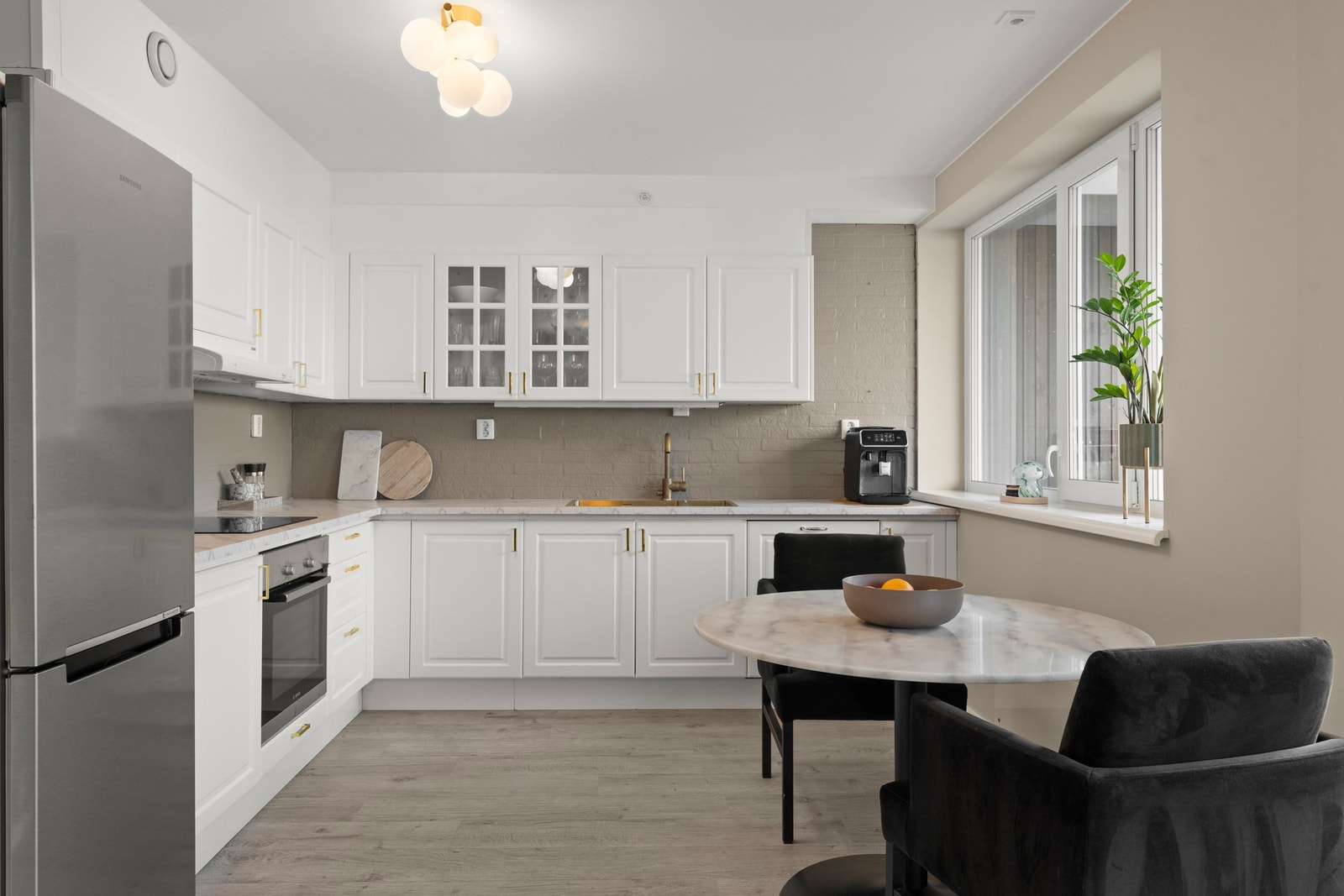 Kjøkkenet fremstår lyst og innbydende med klassisk innredning med profilerte fronter og en praktisk laminatbenkeplate. I 2025 ble benkeplaten skiftet ut, noe som gir kjøkkenet et oppdatert preg og gode arbeidsflater. Over benken er det flislagte vegger so Galleribilde